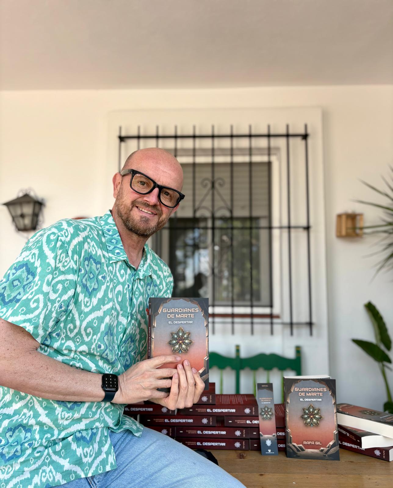 Rafa Gil sosteniendo el primer ejemplar impreso de Guardianes de Marte: El Despertar